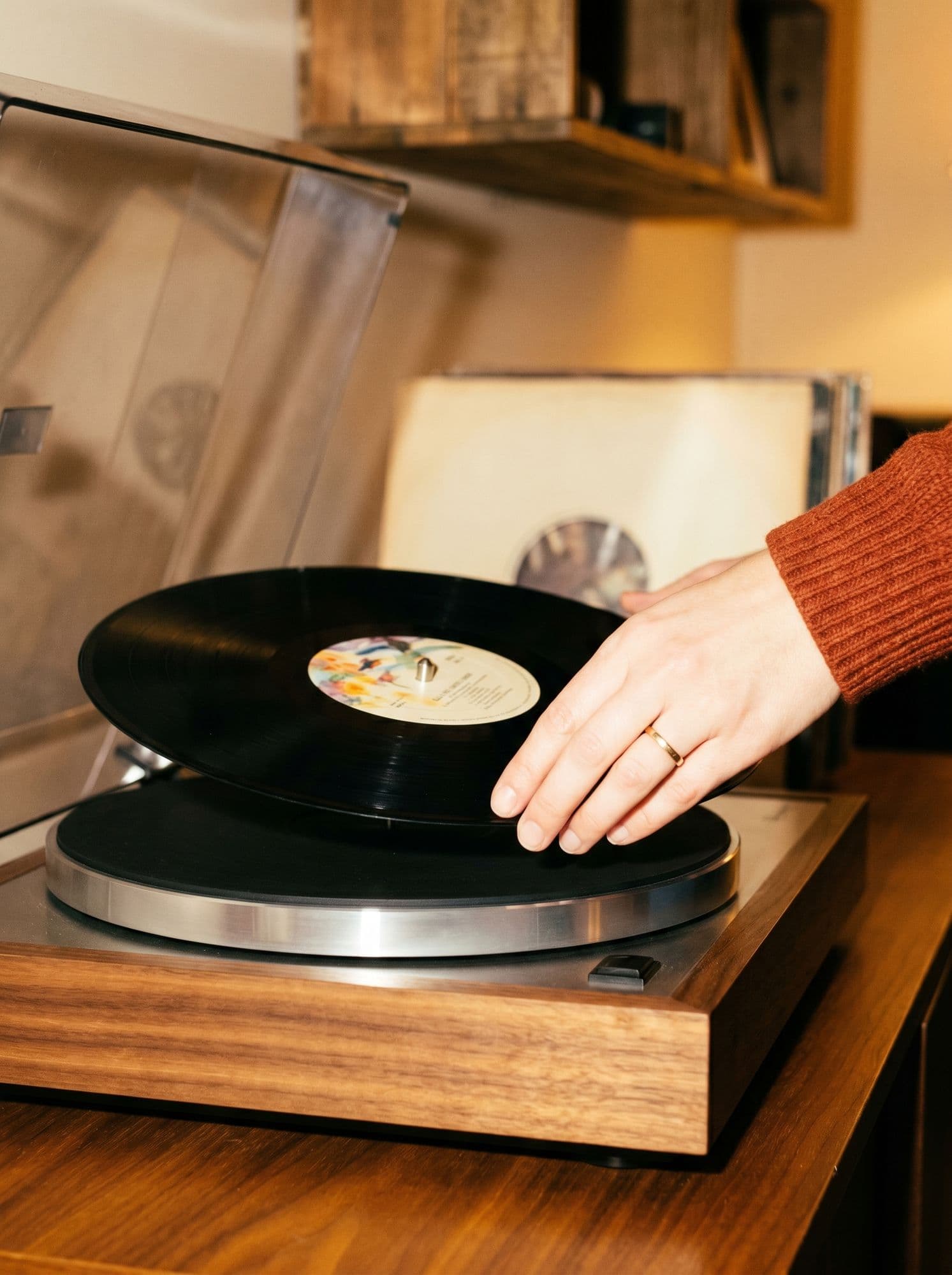 A hand lowering a record onto the turntable